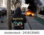 Small photo of Toulon, France - 25-01-2024: A man with a Bob Marley shirt looks at the farmers protesting against government in Toulon, France.