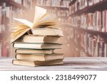 Book with opened pages and stacked books on reading desk in library. National library, books lovers day or month. Back to school or education learning background. Copy space