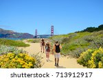 Family on a hiking trip, beautiful summer coastal  landscape.  Golden Gate Bridge, over Pacific Ocean and San Francisco Bay, mountains in the background. Baker Beach, San Francisco, California, USA