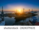 Sunrise bustling sea port, cargo ships docked at berth, cranes poised for unloading. Logistics hub for global trade, freighters ready international delivery. Early morning industrial marine terminal.