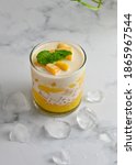 Small photo of A glass of Mango sago, Hongkong dessert made from mango juice, jelly, sago pearl, evaporated milk and sweetened condensed milk. Served cold, White background, Selective focus