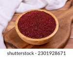 Small photo of Sumac on wooden background. Dried ground red Sumac powder spices in wooden bowl