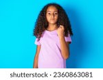 Small photo of beautiful kid girl with afro curly hairstyle wearing pink T-shirt shows fist has annoyed face expression going to revenge or threaten someone makes serious look. I will show you who is boss
