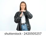 Small photo of Young beautiful woman standing over white studio background being upset showing a timeout gesture, needs stop, asks time for rest after hard work