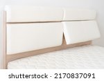 Oak wood bed with white leather adjustable bed headboard.