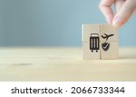 Small photo of Travel safety and travel insurance concept ;wooden cube with grey background, copy space. Intended to cover medical expenses, trip cancellation, lost luggage and other losses incurred while traveling.