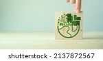 Small photo of Eco friendly, green company culture concept. Carbon neutral and net zero target. Sustainable enviroment and business. Build green community. Hand holds wooden cubes with eco globe on grey background.