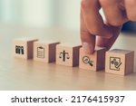Small photo of Audit business concept. Examination and evaluation of the financial statements of an organization; income statement, balance sheet, cash flow statement. Holding wooden cubes with audit icon.