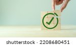Small photo of Corporate regulatory and compliance. Goals achievement and business success. Task completion. Ethical corporate. Do the right thing. Quality and ISO symbol. Wooden cube with green checkmark icon.