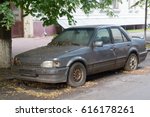 Rusty Abandoned Car On A City...