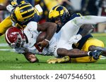 Small photo of Alabama quarterback Jalen Milroe (C)is brought down by Michigan defensive back Makari Paige (R) and defensive back Will Johnson (L) during the 2024 Rose Bowl game Monday, Jan. 1, 2024, in Pasadena.