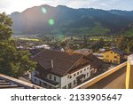 View of Green hillside with sun flare in small alpine town of St. Johann Im Pongau in Austria