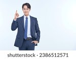 A young and handsome Asian man in a suit is wearing glasses and making various facial expressions and hand gestures.