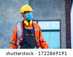 Electrician wearing protective mask to Protect Against Covid-19 and checking production process at the construction site,Engineer,Construction concept,Coronavirus has turned into a global emergency.