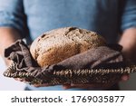 Mad is holding basket with freshly homemade wholemeal bread. Easy Cooking of healthy bread from alternative flours