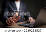 Small photo of Businessman using a laptop and touching on virtual screen contact icons consists of telephone, email, address, live chat, internet wifi, Contact us or Customer care support hotline people connect.