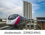Small photo of BANGKOK,THAILAND,November 28 2023 .Bangkok Metropolitan Rapid Transit pink Line, MRT Pink Line is slowing down when entering a curve that looks leaning when passing a condominium in the near distance.
