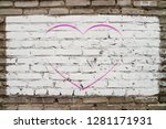 Small photo of Pink drawn heart on brick wall with white paint close-up. Mock up. Urban background with pink painted heart. Imperfect exterior with love symbol graffiti. Valentine day image. Unideal brickwork.