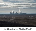 Small photo of BOXBERG, GERMANY - 29. December 2022: Landscape in a brown coal mining area with a lignite power plant. The destroyed nature is dull and depressing. Real wasteland in an industrial country in Europe.