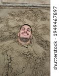 Man Buried In The Sand On A...