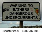 Small photo of Portstewart, Northern Ireland - 08/21/2020: 08/21/2020: A sign next to a beach saying 'Warning to Bathers Dangerous Undercurrents'