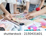 Young team asian designer women working at studio. Fashion designer carefully creating new fashionable styles. Dressmaker makes clothes job