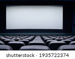 Movie theater with black seats and large blank screen. Concept of empty cinema hall.