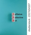 Small photo of IRA inflation reduction act symbol. Concept red words IRA inflation reduction act on wooden cubes on beautiful blue background. Business IRA inflation reduction act concept. Copy space.