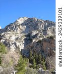 Small photo of Delphi, Greece - January 3, 2022: Eastern rock Flemboukos (Flame) - one of the inaccessible rocks of the Phaedriades rock rises on the southern slope of Parnassus above the Kastalian spring.