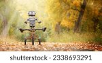 Small photo of Happy humanoid robot rides a bicycle along the autumn alley. Robotic object experiences feelings and emotions. Concept of technology development in the form of artificial intelligence.