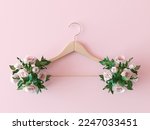 Small photo of Clothes hanger with flowers on pink background. Flat lay, top view minimalistic composition. Creative hanger for wedding dress. Wooden coat hanger and pastel colorful flowers, creative arrangement.