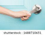 Hand open door knob blue background