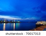 View on seaport with cranes, cargo and passenger ships at the night.