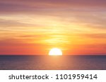 Bright sunset with large yellow sun under the sea surface