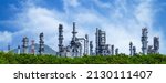 Small photo of Oil refinery plant from industry zone, Oil and gas petrochemical industrial with tree and blue sky background, Refinery factory oil storage tank and pipeline steel, Ecosystem and healthy environment.