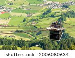 Tourists (faces not visible) climbing the cable car in an open car up Mount Stanserhorn in Switzerland and admire the magnificent aerial panorama of central Switzerland, mountains, villages and forest