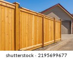 Nice new wooden fence around house. Wooden fence with lawn. Street photo, nobody, selective focus