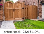 Backyard with wooden new gates. Gate, fence, home entrance. Front of a house with wooden gate. Nobody, street photo