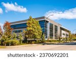 Small photo of Architectural facade building with of glass elements. Exterior of a modern industrial building. Modern Business Gray Contemporary Building in Urban Street Setting. Corner Business Building