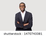 Happy african american young businessman in formal suit wearing eyeglasses portrait. Smiling millennial confident black guy posing for photo, looking at camera, isolated on grey studio background.