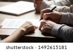 Small photo of Solicitor pointing at insurance contract showing male client where to write signature sign sale purchase employment agreement at meeting make financial business deal, bank loan service, close up view