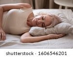 Small photo of Close up of calm senior woman lying on side sleeping peacefully in comfortable bed soft pillow, tired elderly female or grandmother rest fall asleep taking nap in cozy bedroom, relaxation concept