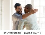 Small photo of Smiling Caucasian man in glasses feel overjoyed meeting ethnic male friend or colleague, happy young multiethnic guys hug embrace tapping shoulder excited encounter at party, friendship concept