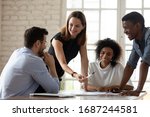Caucasian woman team leader mentor teach staff multiethnic workers at corporate group briefing explain work results analyzing financial report together, planning project, brainstorming process concept