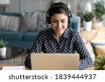 Small photo of Attractive indian woman sit at homeoffice room wearing headset take part in educational webinar using laptop. Video call event with clients or personal chat with friend remotely concept