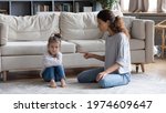 Small photo of Strict young Caucasian mother talk lecture ill-behaved stubborn small preschooler daughter at home. Serious mom scold unhappy naughty little girl child kid. Family fight, generation gap concept.