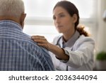 Serious GP doctor giving support to elderly 80s patient after telling bad news, holding, touching shoulder. Older man getting bad diagnosis, hard mental disease, late cancer. Elderly medic care