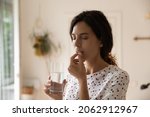 Small photo of Stressed tired woman taking vitamins, painkillers, antidepressants, pills, meds against headache, insomnia, nervous disorder, anxiety. Patient with medication fighting against flu infection, migraine