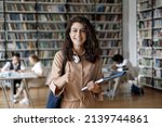 Small photo of Attractive student 18s girl standing in library showing thumbs up, enjoy interesting effective studies in higher institution. Successful excellent learner, scholarship, good quality education concept