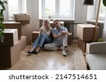 Small photo of Sad tired elderly couple sit on floor near boxes with packed stuff feel exhausted due to long relocation. Hard difficult moving day, bank debt, owner eviction, financial problem, foreclosure concept